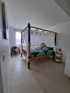 莱特鲁瓦西莱Villa Les Oursins 130 m² - Piscine privée的一间卧室配有一张带天蓬的床