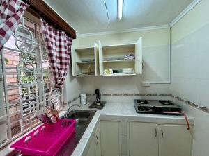 内罗毕Charming Retreat in Garden Estate-Thome, Thika Rd的厨房配有粉色水槽和窗户