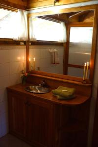 圣卡洛斯-德巴里洛切Estancia La Esperanza的浴室设有水槽、镜子和蜡烛
