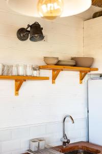 德尔迪阿布罗角Cabaña Agua de Mar的厨房的墙上设有木制架子