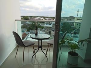 里奥阿查Hermoso apartamento frente al mar的阳台配有桌椅和窗户。