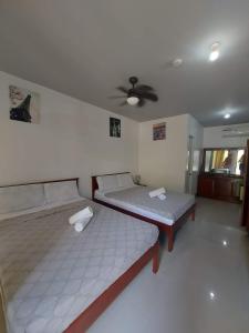莫阿尔博阿Garden Village Resort的配有吊扇的客房内的两张床