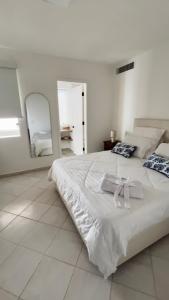 AricaguaCimarron Suites Playa Parguito的白色卧室配有一张大床和两条毛巾