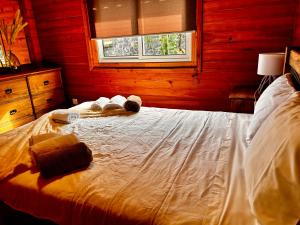卡佩拉什Vila Emigrante的木制房间的一个床位,上面有毛巾