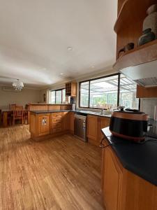 WoollamiaAt holiday house的大型厨房铺有木地板,设有大窗户。