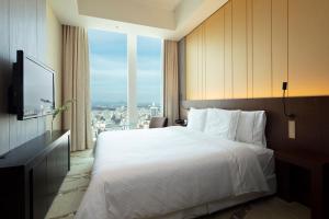 仙台The Westin Sendai的酒店客房设有一张床和一个大窗户
