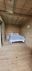 卡利Kuyana Glamping的木制客房内的一间卧室,配有一张床