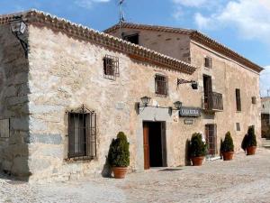 莱德斯马La Clerecia de Ledesma的前面有盆栽植物的石头建筑