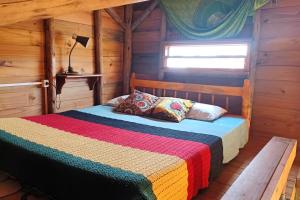 托雷斯Chalé Tribos Livres的小木屋内一间卧室,配有一张床