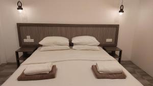 迪弗西Nirili Villa的一张大床,带两个枕头和两个毛巾