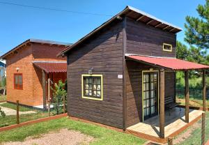 托雷斯Chalé Tribos Livres的一座带红色屋顶的小木房子