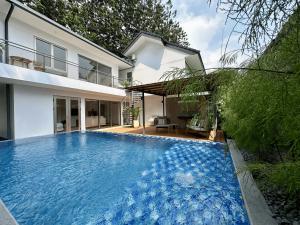 万隆Bungalow Homes的一座大蓝色游泳池,位于房子前