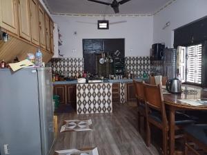BhurkīāBardiya Eco Safari Homestay的厨房配有桌子和冰箱