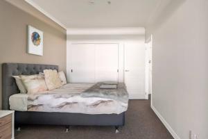 奥克兰Luxury Apartment With Stunning Harbour & City View的一间卧室设有一张大床和大窗户