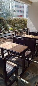 马尼萨莱斯Hotel Palo Grande的阳台上的一组木桌和长凳