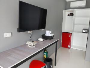 MaribagoCASABLU HOTEL&RESORT的一间带电视和红椅的客厅