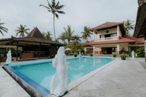 BalianBali Hai Island Resort的站在游泳池旁的女人雕像