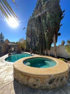 洛杉矶Charming 6BR Family Home with Private Pool -ENC-UC的一座大型游泳池四周环绕着石头