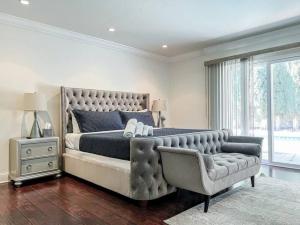 洛杉矶Charming 6BR Family Home with Private Pool -ENC-UC的一间卧室配有一张大床和一把椅子