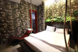 胡志明市Loove Hotel - Khách Sạn Tình Yêu的卧室配有秋千床和植物