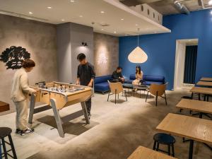 东京Hotel Plus Hostel TOKYO ASAKUSA 1的一群人在房间里下棋