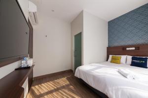 雅加达Urbanview Hotel Cengkareng Jakarta by RedDoorz的一间卧室配有一张床和一台平面电视