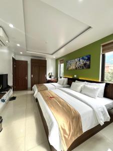 河江Phúc Lâm Hotel的一间大卧室,配有两张床和电视