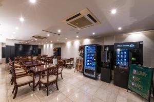 首尔New Cheonji Hotel的配有桌椅和自动售货机的餐厅