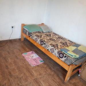 埃博森Casa estilo cabaña的铺有木地板的客房内的一张小床