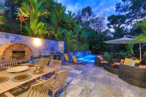奎波斯城Villa with jungle view & pool near Manuel Antonio的一个带桌椅的庭院和一个游泳池