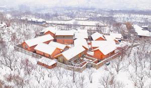 怀柔慕田峪三卅精品酒店的雪覆盖的房子的空中景色
