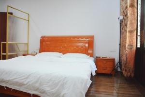 梅州湄洲岛悦榕湾民宿的卧室内的一张带木制床头板的床