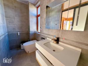 丽江丽江拾田民宿的一间带水槽、卫生间和镜子的浴室