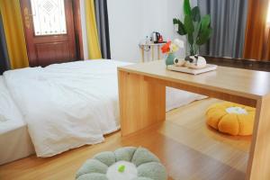 梅州湄洲岛悦榕湾民宿的一间卧室配有一张床、一张桌子和两个枕头