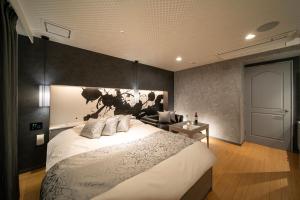 姬路ホテル継kei男塾ホテルグループ的一间卧室配有一张大床和一张沙发