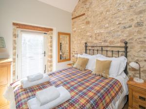 Rosedale Abbey2 Bed in North York Moors National Park G0132的一间卧室设有一张床和石墙