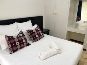 马盖特Sombedu guest suite的一张带枕头和毛巾的白色床