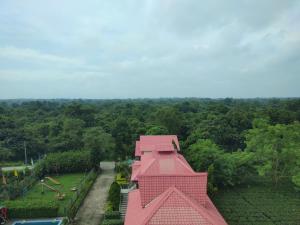 Alīpur DuārMaa Greenary View - A Holiday Resort的公园内一座粉红色的建筑,设有游乐场