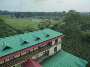Alīpur DuārMaa Greenary View - A Holiday Resort的享有带绿色屋顶的建筑的顶部景色