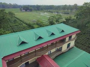 Alīpur DuārMaa Greenary View - A Holiday Resort的享有带绿色屋顶的建筑的顶部景色