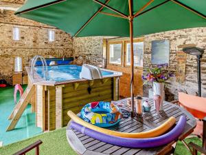 Pont Newydd1 Bed in Abergavenny BN113的庭院设有热水浴池和带遮阳伞的桌子。