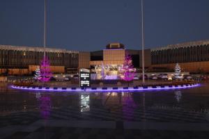 塔伊夫塔伊夫洲际酒店的一座建筑前方种有紫色树木的庭院