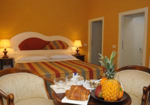 巴尼奥迪罗马涅Albergo Roma的酒店客房设有一张床和一张带 ⁇ 萝的桌子。