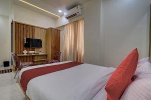 纳威孟买HOTEL VICTORY INN的酒店客房配有一张床、一张书桌和一台电视。