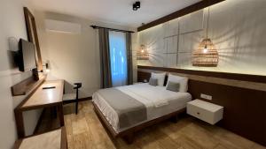 阿奇亚卡İskelem Otel的一间卧室配有一张床、一张书桌和一台电视