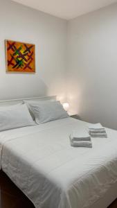 佩鲁贾Casa Valentina 1的一张白色的床,上面有两条毛巾