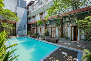 玛琅RedDoorz Premium @ Jalan Cengkeh Malang的一座建筑的庭院中的游泳池