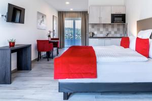 MontilliezMotel-Résidence Ô Pied à Terre的卧室配有带红色枕头的大型白色床