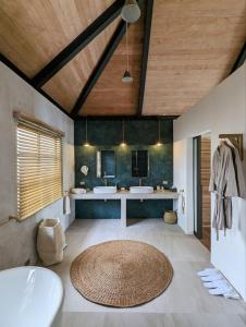 卢纳将军城卡丽娜沃度假村的大型浴室设有两个盥洗盆和大地毯。