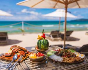 邦涛海滩The Lazy Coconut Glamping的海滩上一张带食物盘的桌子